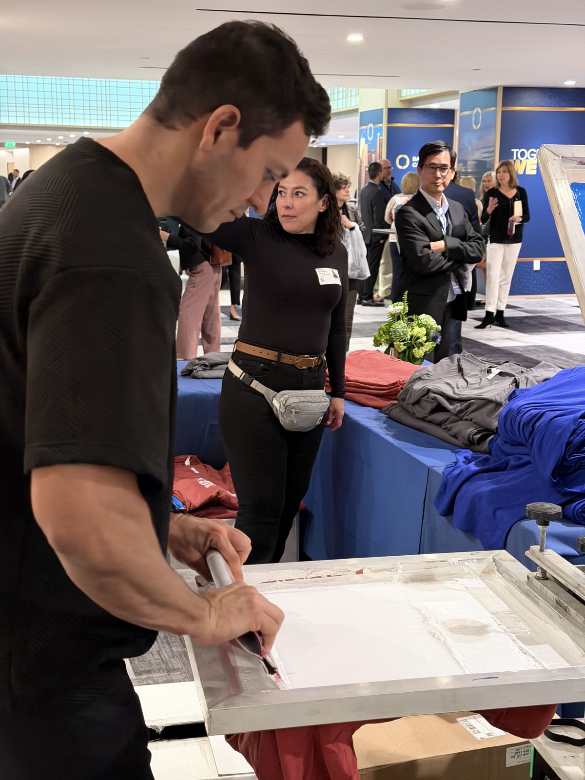 Guests watching a crew member pull a live print at an upscale reception